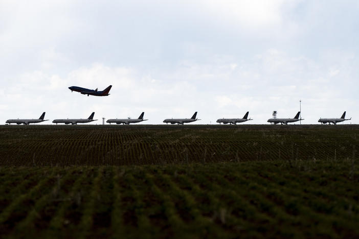 A Southwest Airlines flight takes off as United Airlines planes sit parked on a runway at Denver International Airport in April.