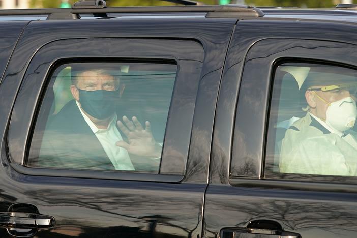 Dr. James Phillips is no longer working at Walter Reed National Military Medical Center, months after criticizing President Trump's flouting of coronavirus safety guidelines. Here, Trump waves to supporters from an SUV in October as he was driven outside the facility in Bethesda, Md.