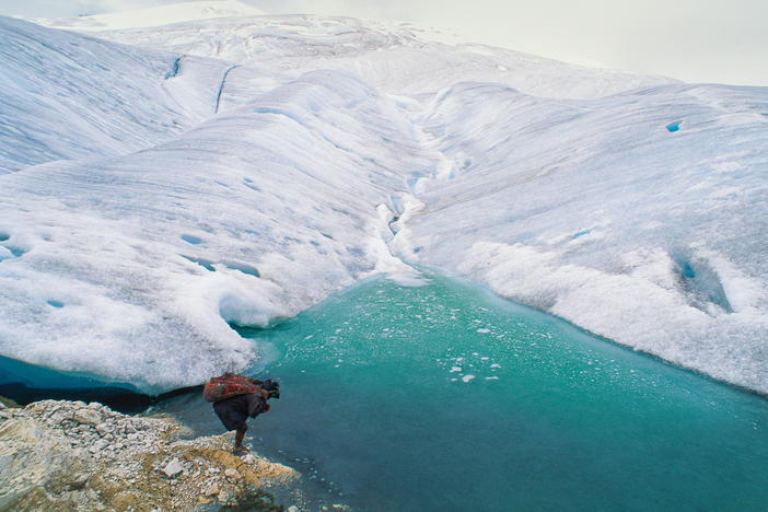 A barefoot porter totes a load for an expedition visiting one of the remaining glaciers near the equator, 16,000 feet high on the highest peak in Papua, Indonesia.