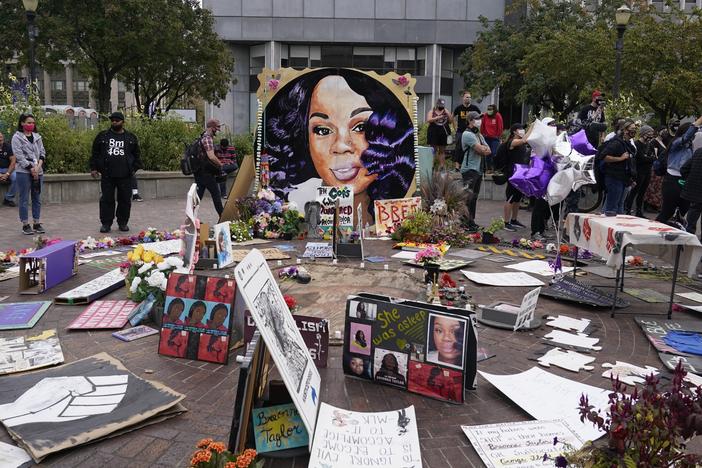 Two more Louisville police officers have been told they will be fired in the wake of the death of Breonna Taylor, whose image is seen in a memorial in September.