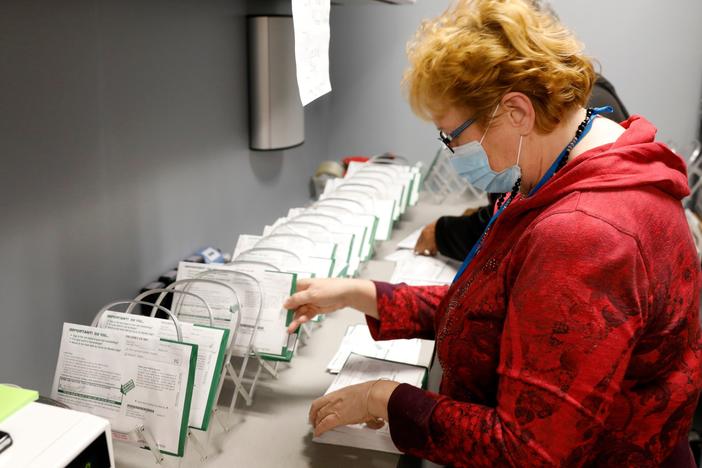 A West Bloomfield, Mich., Clerk's Office employee sorts absentee ballots by the precinct and ballot number on Oct. 31.