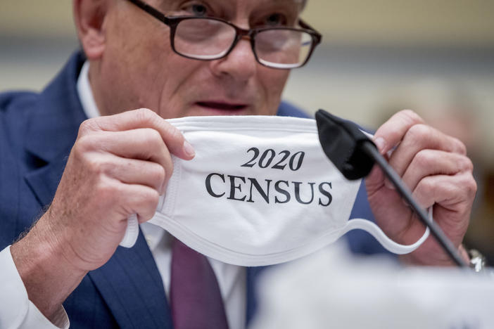 Census Bureau Director Steven Dillingham holds up his mask with the words "2020 Census" as he testifies before a House Committee on Oversight and Reform hearing on the census in July.