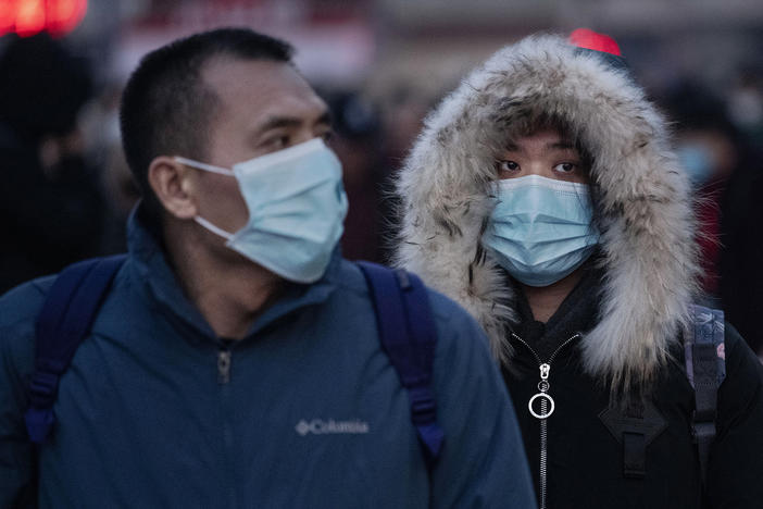 Chinese travelers at a railway station in Beijing, China, wear face masks to protect themselves from the new coronavirus on Jan. 21, 2020. The virus was first identified in Wuhan, China, in Dec. 2019, and since then has quickly spread worldwide.