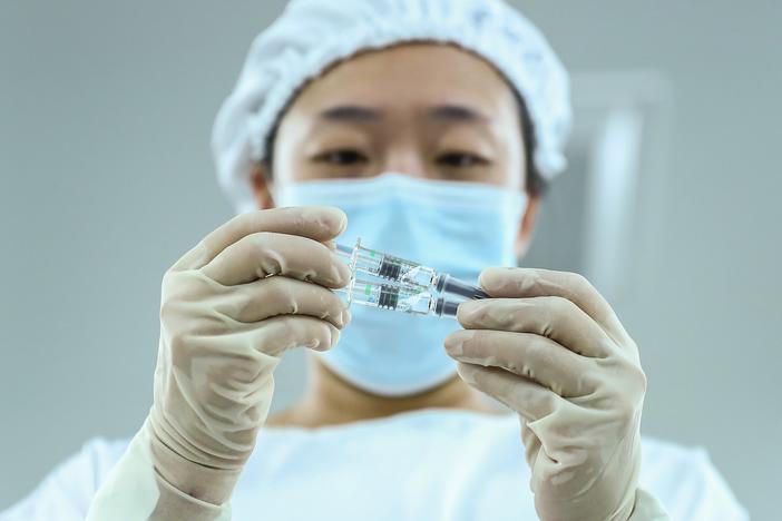A staff member checks a COVID-19 vaccine package in Beijing. China has approved Sinopharm's vaccine after clinical trials showed it has a 79% efficacy against COVID-19.