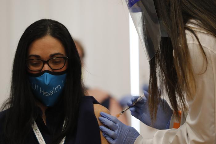 Dr. Nikhila Juvvadi gives Dr. Marina Del Rios from the University of Illinois Hospital & Health Sciences System one of the first COVID-19 vaccination administered in Chicago on Dec. 15 at Loretto Hospital on the city's West Side.