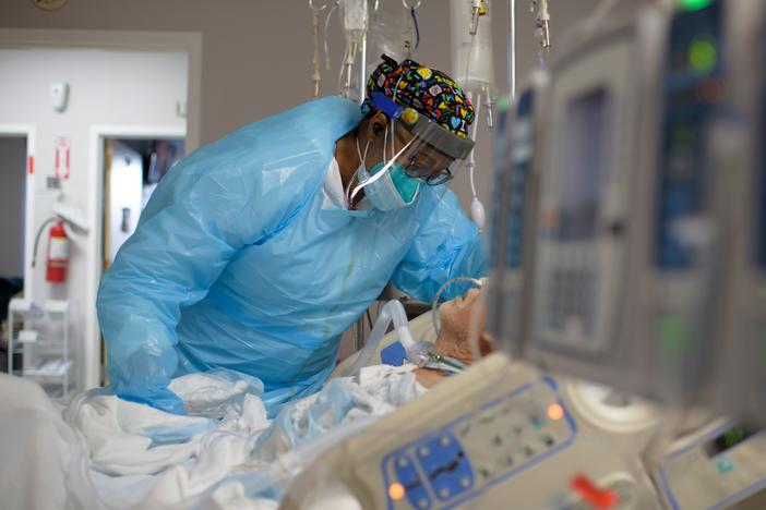 Health care worker Demetra Ransom comforts a patient in the COVID-19 ward at United Memorial Medical Center in Houston, Texas. on Dec. 4. The U.S. has surpassed 20 million confirmed coronavirus cases.