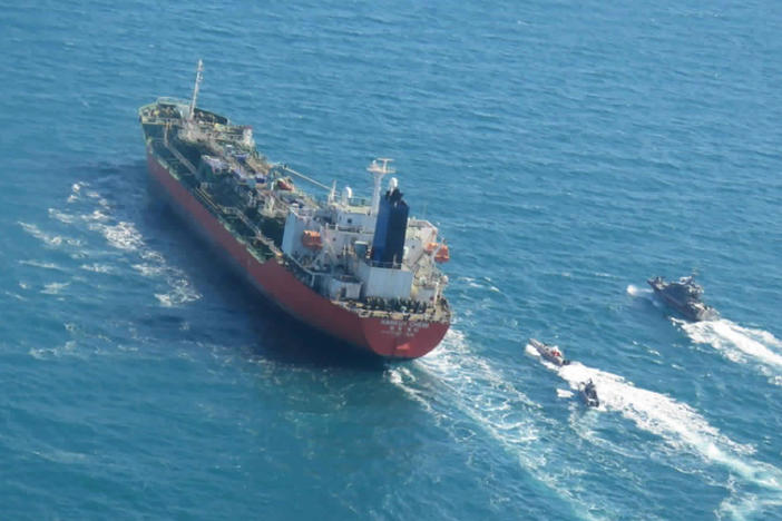 A seized South Korean-flagged tanker is escorted by Iranian Revolutionary Guard boats in the Persian Gulf. This comes as Tehran is enriching nuclear fuel to 20% purity.