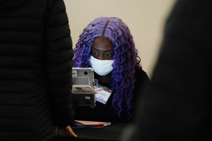 A poll worker registers voters before they cast their ballot in Georgia's Senate runoff elections Tuesday in Atlanta.