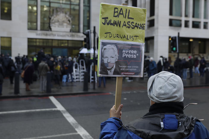 A Julian Assange supporter holds up a placard of the WikiLeaks founder outside Westminster Magistrates Court, the site of his bail hearing, in London on Wednesday.
