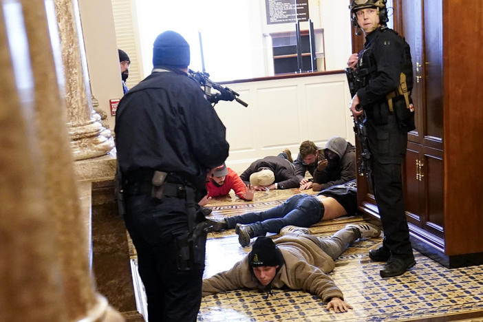 U.S. Capitol Police hold protesters at gunpoint near the House Chamber inside the U.S. Capitol on Wednesday.