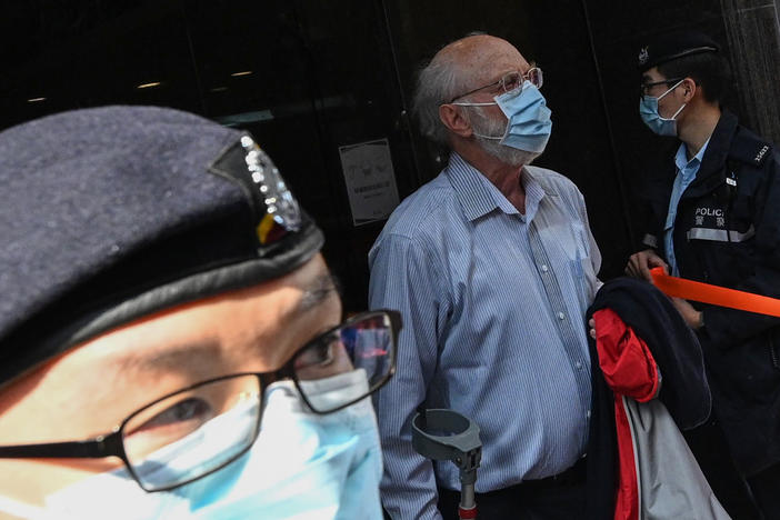 John Clancey, a U.S. attorney who is known for taking on human rights cases, is led away Wednesday by police after his arrest in Hong Kong under a new Beijing-imposed national security law.