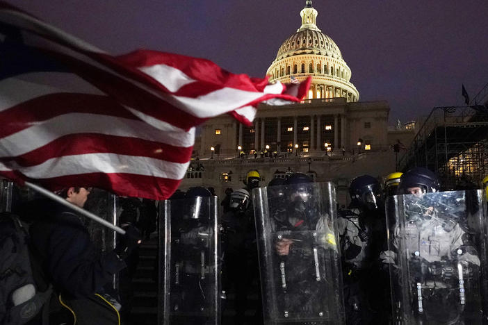Police stand behind their shields outside the Capitol after a day of rioting on Wednesday.