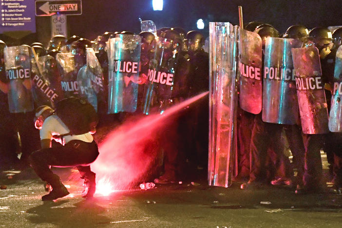 An anti-racism protester near Lafayette Square in Washington, D.C., in May is tear-gassed as he attempts to retrieve a flare thrown at police.