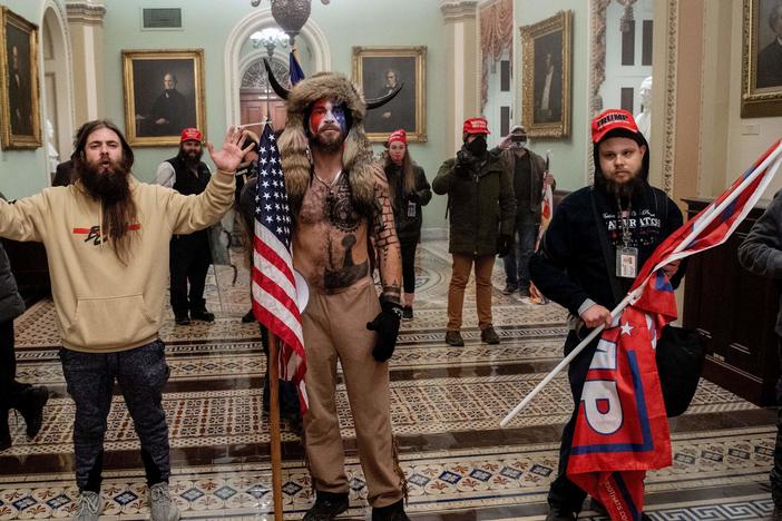 Supporters of President Trump, including Jake Angeli (center), a QAnon supporter known for his painted face and horned hat, stand inside the U.S. Capitol on Jan. 6. Demonstrators breached security and entered the Capitol as Congress was in the process of tallying the 2020 electoral vote count.