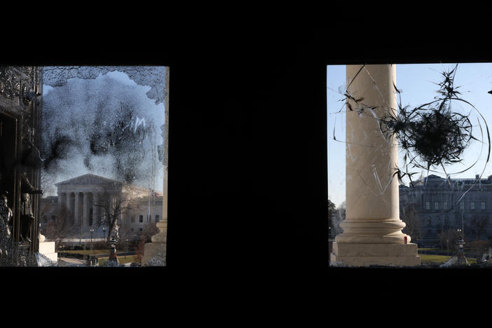 The U.S. Supreme Court is seen through a broken window at an entrance of the U.S. Capitol Wednesday.