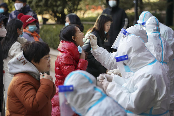 In this photo released by Xinhua News Agency, medical workers take swabs from residents in Shijiazhuang in north China's Hebei province on Jan. 6. Authorities have announced new restrictions to contain the coronavirus.