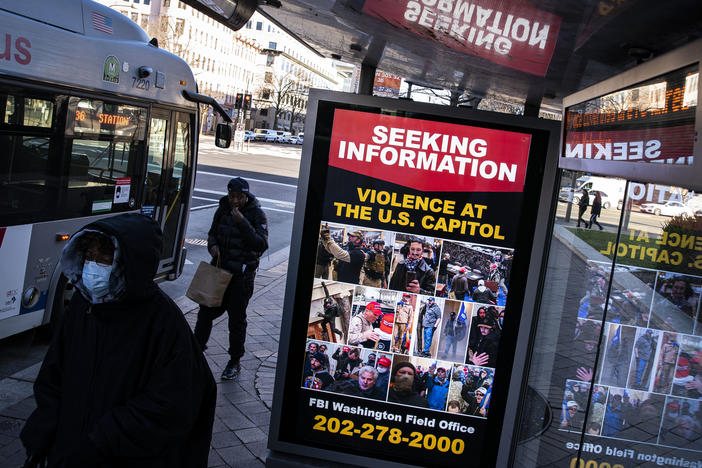 At a bus stop on Pennsylvania Avenue Northwest in Washington, D.C., a notice from the FBI seeks information about people pictured during the riot at the U.S. Capitol on Wednesday.