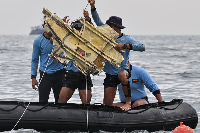 Indonesian Navy divers hold wreckage from Sriwijaya Air flight 182 during a search and rescue operation at sea near Lancang island on Sunday.