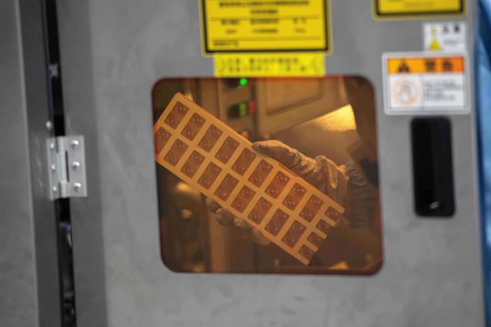 A worker is seen inside the production chain at Renesas Electronics, a semiconductor manufacturer, in Beijing on May 14, 2020. A global computer chip shortage is affecting automakers.