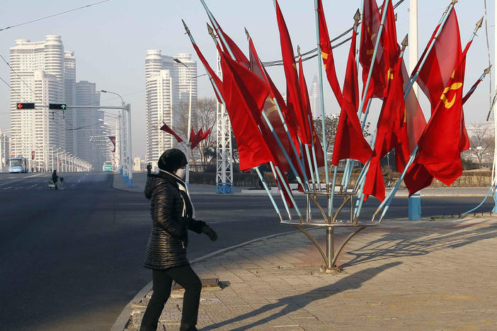 A person passes by a bouquet of Workers Party flags along a main street of the Central District in Pyongyang, North Korea, last week.
