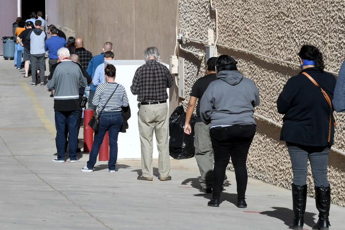 People line up on Thursday for the first day of Clark County's pilot COVID-19 vaccination program at Cashman Center in Las Vegas.