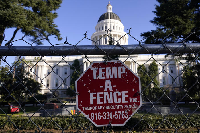 A temporary 6-foot-high chain-link fence now surrounds California's state Capitol. Gov. Gavin Newsom said Thursday, "Let me be clear: There will be no tolerance for violence."