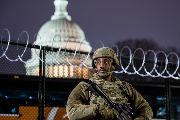 A member of the Virginia National Guard stands outside the razor wire fencing surrounding the U.S. Capitol on Friday. Up to 25,000 troops are expected by Inauguration Day.