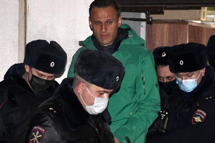 Opposition leader Alexei Navalny is escorted out of a police station in Khimki, outside Moscow, following the court ruling that ordered him jailed for 30 days.