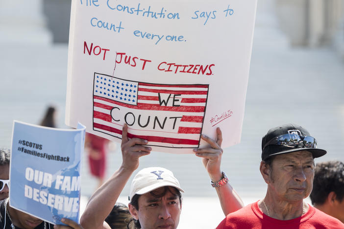 Protesters hold signs at a rally about the 2020 census in front of the U.S. Supreme Court in 2019. President-elect Joe Biden has revoked the Trump administration's policy of excluding unauthorized immigrants from population numbers used to reallocate congressional seats and Electoral College votes.