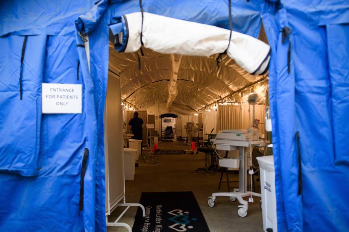 A field hospital tent for suspected COVID-19 patient triage was set up outside the emergency department of Martin Luther King Jr. Community Hospital in Los Angeles, California. A surge in deaths has prompted the county to lift environmental limits on the number of cremations that can be performed each month.