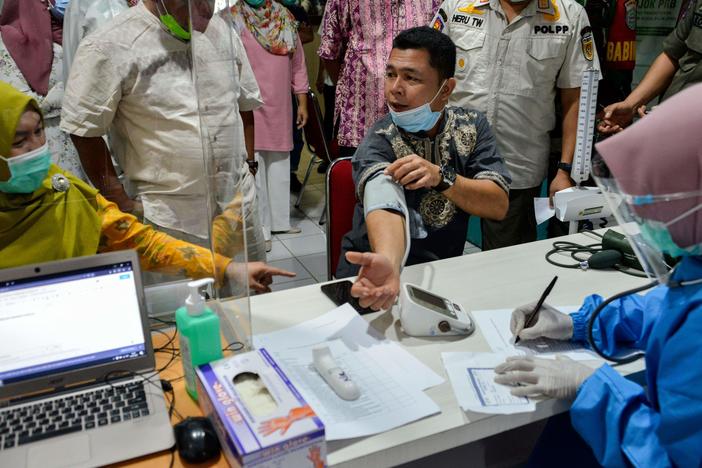 An official has a blood pressure test before receiving the Sinovac coronavirus vaccine, developed in China, at a hospital in Banda Aceh, Indonesia, on January 15.
