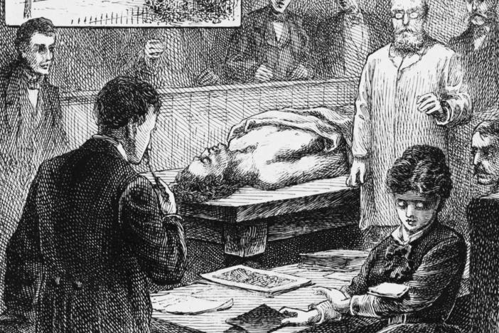 An illustration shows medical student Elizabeth Blackwell at Geneva Medical College (later Hobart College) in upstate New York, as she eyes a note dropped onto her arm by a male student, during a lecture in the college's operating room.