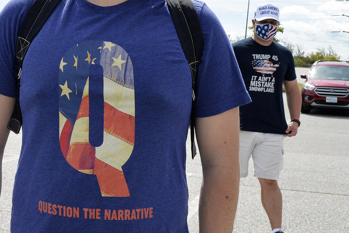 A man wears a QAnon shirt while boarding a shuttle bus in Londonderry, N.H., on Aug. 28, 2020.