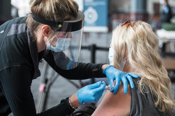 A woman receives the COVID-19 vaccine last week at Gillette Stadium in Foxborough, Mass. Setting up community vaccination centers will be a key to getting the vaccine to millions, an adviser to President Biden says.