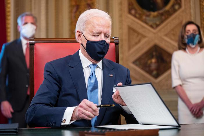 President Biden signs documents in the Presidents Room at the U.S. Capitol after taking the oath of office.