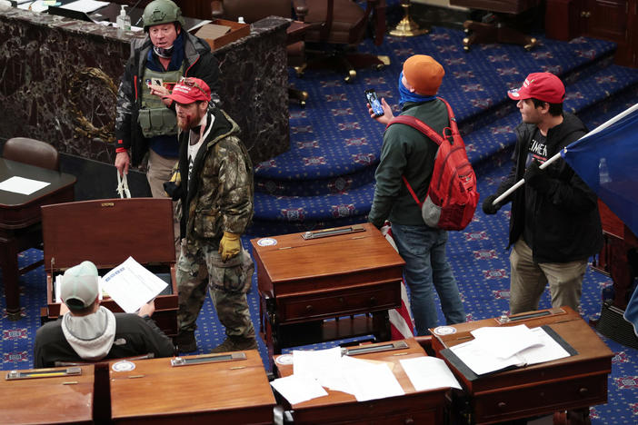Larry Rendall Brock Jr., an Air Force veteran, is seen inside the Senate Chamber wearing a military-style helmet and tactical vest during the rioting at the U.S. Capitol. Federal prosecutors have alleged that before the attack, Brock posted on Facebook about an impending "Second Civil War."