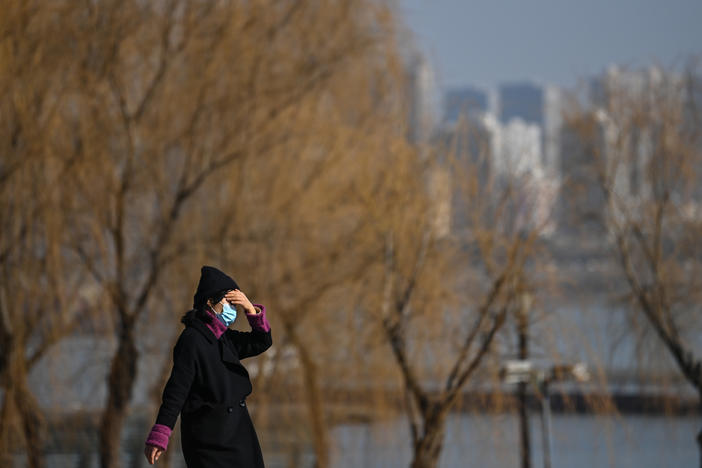 A woman walks in a park along Yangtze River in Wuhan on Jan. 19, 2021. Residents of the city of 11 million, which was the first epicenter of COVID-19, have conflicting emotions as they reckon with the aftermath of the virus and their 76-day lockdown.