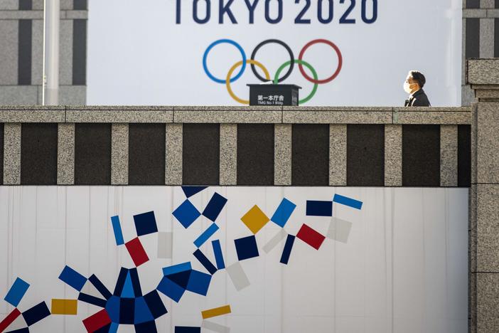 A pedestrian walks past an official Tokyo 2020 Olympic Games banner hanging on the Tokyo Metropolitan Government Building on Friday.