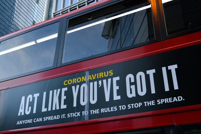 Moderna will test new COVID-19 vaccine booster doses, saying that while its vaccine should protect against variants found in the U.K. and South Africa, it isn't as effective against the South African strain. Here, a bus in London carries a sign telling people, "Act Like You've Got It" — to prevent the coronavirus from spreading.