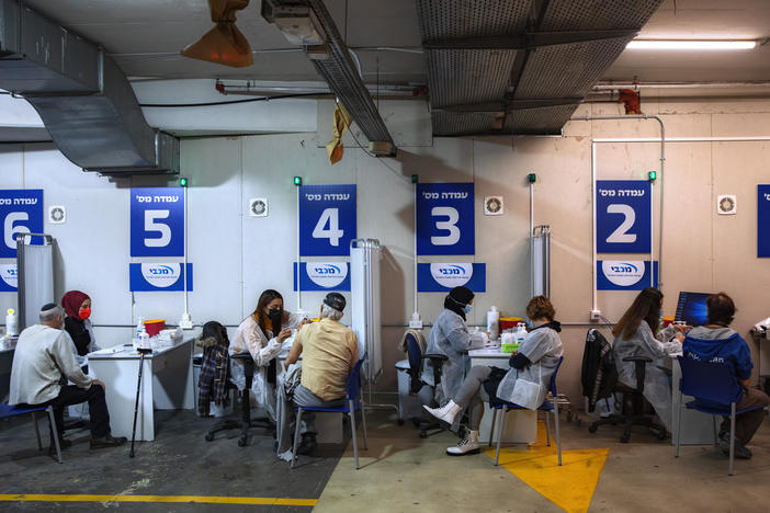 Israelis receive a Pfizer-BioNTech COVID-19 vaccine from medical professionals at a vaccination center set up on a mall parking lot in Givataim, Israel, during a nationwide lockdown to curb the spread of the virus, on Jan. 20.