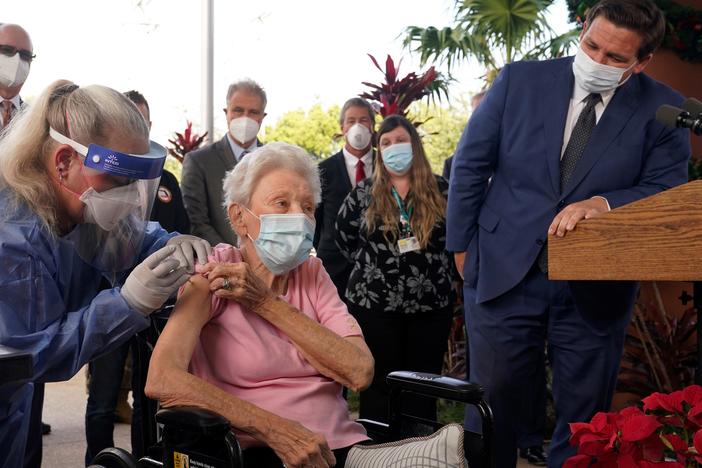 Florida Gov. Ron DeSantis watches as nurse Christine Philips (left) administers the Pfizer-BioNTech vaccine for COVID-19 to Vera Leip, 88, a resident of John Knox Village, Wednesday, Dec. 16, 2020, in Pompano Beach, Fla.