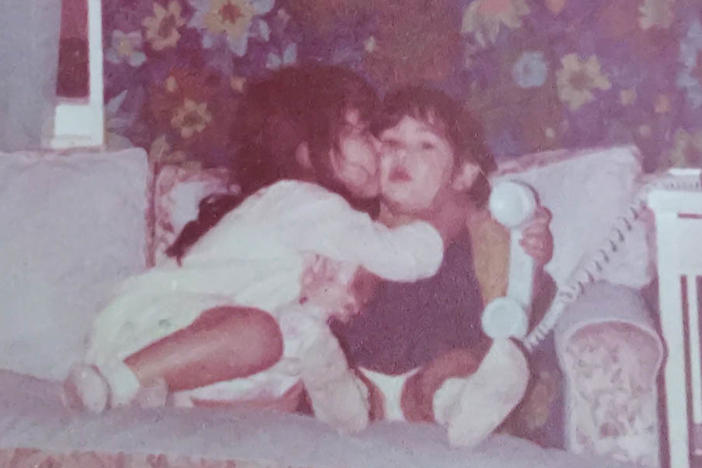 Brenda Ulloa Martinez (left), then 4, and younger sister Corina Ulloa, 2, are pictured in the living room of their one-bedroom apartment where they lived with their parents.