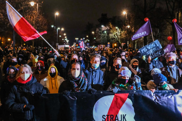 Protesters against new restrictions on abortion walk toward the Law and Justice Party headquarters on Wednesday night in Warsaw. A Constitutional Court ruling in October determined that abortions are only legal in cases of rape and incest, and when the mother's health or life is in danger.