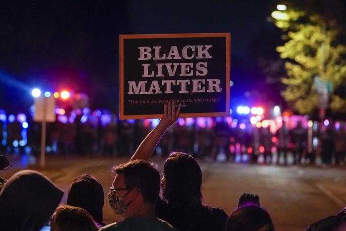 Protesters and police face off in Wauwatosa, Wis., in October, after the district attorney refused to charge Officer Joseph Mensah in the shooting death of Alvin Cole early last year.