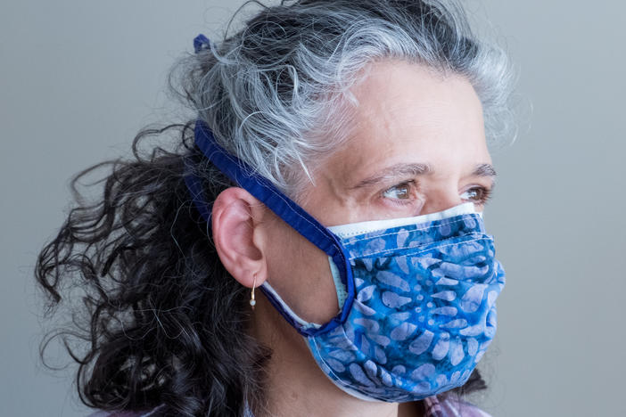 Layering a cloth mask on top of a surgical mask helps achieve a tighter fit while also adding an extra layer of filtration. Double-masking like this increases protection against the coronavirus.