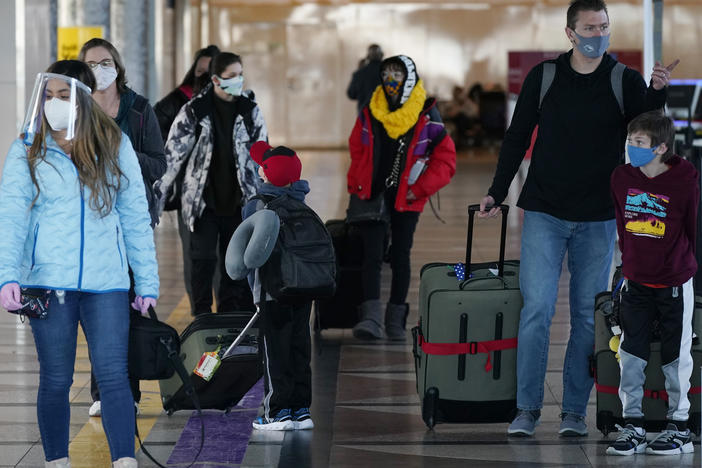 Masked travelers head through the main terminal of Denver International Airport on Dec. 31. Starting Feb. 1, travelers will be required to wear face masks on nearly all forms of public transportation.