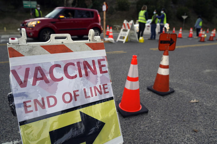 Drivers with an appointment enter a COVID-19 vaccination site set up in the parking lot of Dodger Stadium in Los Angeles on Saturday. One of the largest vaccination sites in the country, it was temporarily shut down Saturday afternoon because of protesters, stalling hundreds of motorists who had been waiting in line for hours.