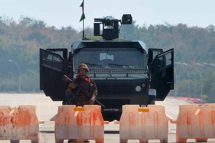 A soldier stands guard on a blockaded road to Myanmar's parliament in Naypyidaw on Monday, after the military detained the country's de facto leader Aung San Suu Kyi and other officials and activists.