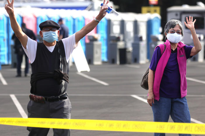 Southern Californians celebrate at a mass vaccination site in Disneyland's parking lot in January. CDC head Dr. Rochelle Walensky cautions that for strongest immunity, recipients get both doses of the Pfizer or of the Moderna vaccine.