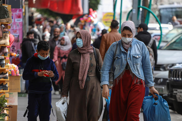 People wear face masks on a shopping street in Gaza City in January.